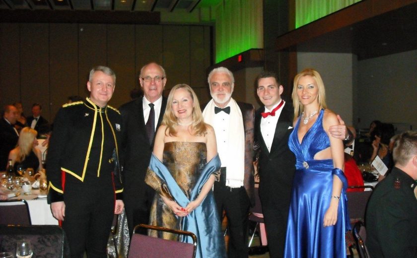 Garrison Ball, four men wearing suits and two women wearing gold and blue dresses