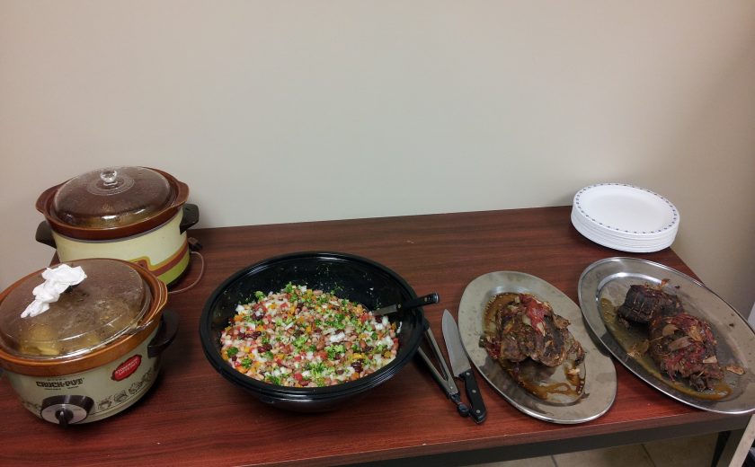 two brown and white pots, black bowl with colourful chopped vegetables, two silver plates with food on a brown table