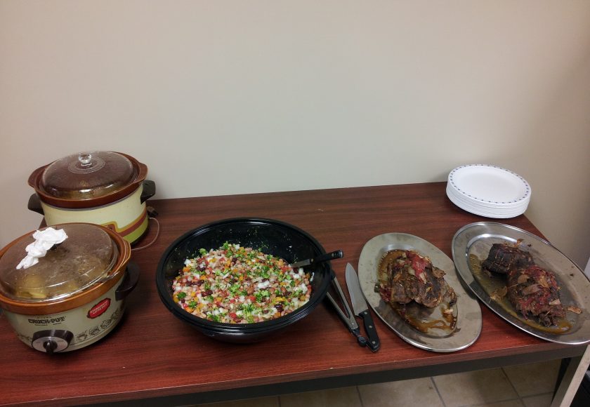 two brown and white pots, black bowl with colourful chopped vegetables, two silver plates with food on a brown table