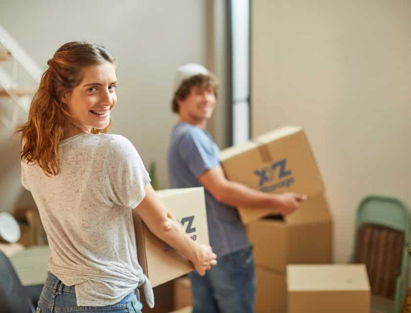 boy wearing a blue t-shirt and girl wearing white t-shirt holding XYZ Storage moving boxes