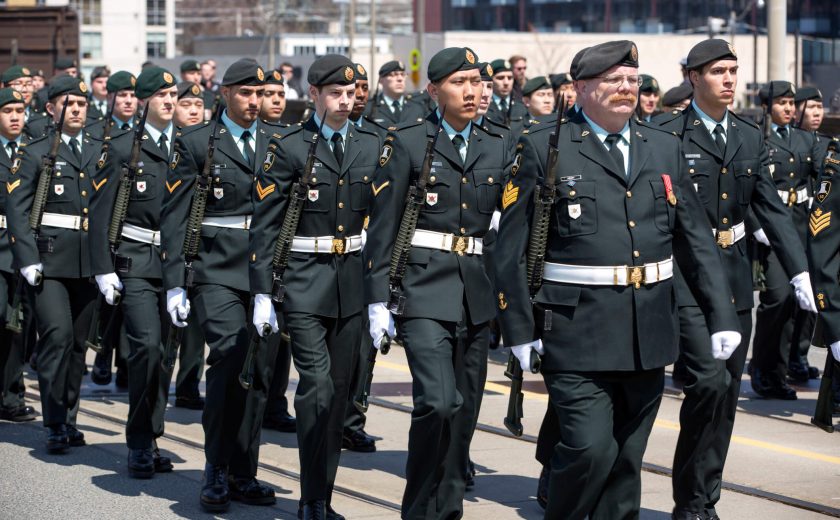 Group of men walking the city streets, wearing a black military uniform