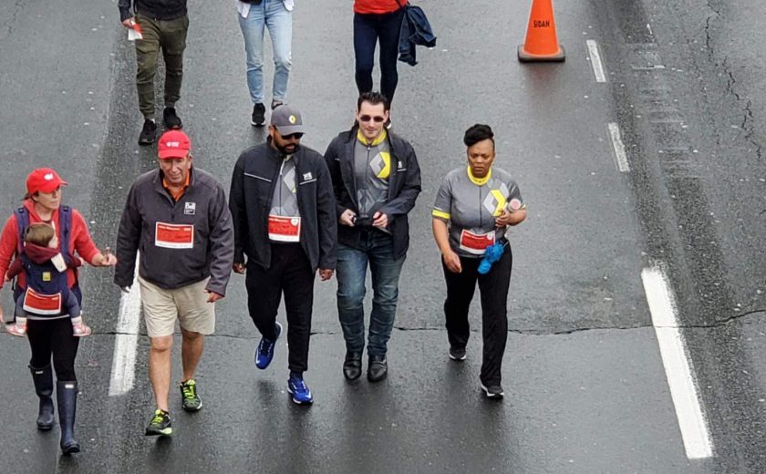 XYZ storage team walking on the highway, wearing grey, yellow, and red