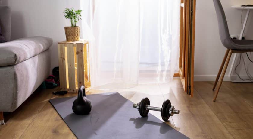 Kettlebell and weights on yoga mat in living room