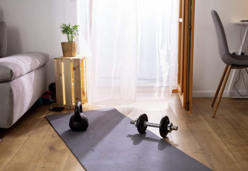 Kettlebell and weights on yoga mat in living room