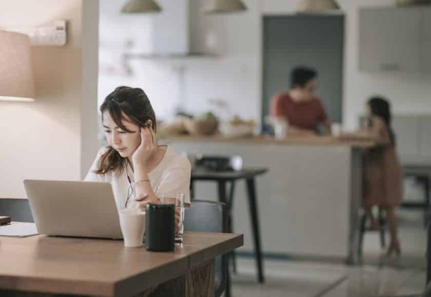 an asian chinese mid adult woman working in dining room typing using her laptop